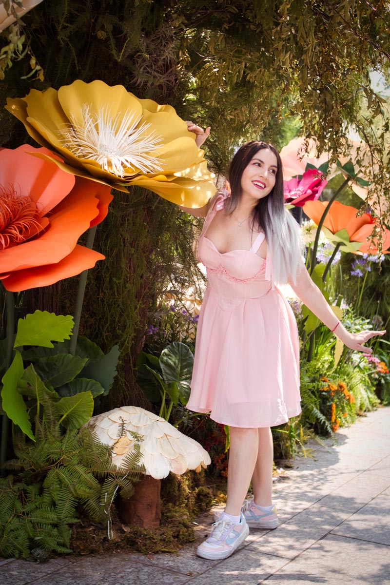 Magali Castagno con vestido rosa bajo flores gigantes de papel, sesión de moda editorial en el Festival de Flores, Ciudad de México, fotografía por Josué Palma