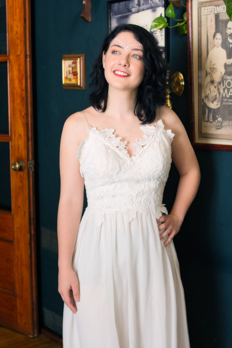 Retrato de Victoria Daninisa con vestido blanco de encaje, mirada hacia un costado, sesión editorial en interior vintage, Ciudad de México, fotografía por Josué Palma